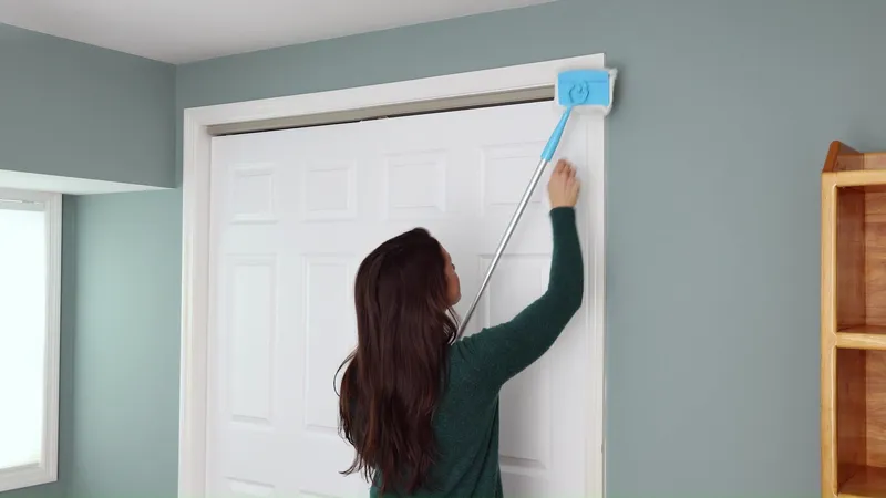 Cleaning head on the top of a door casing, handle extended