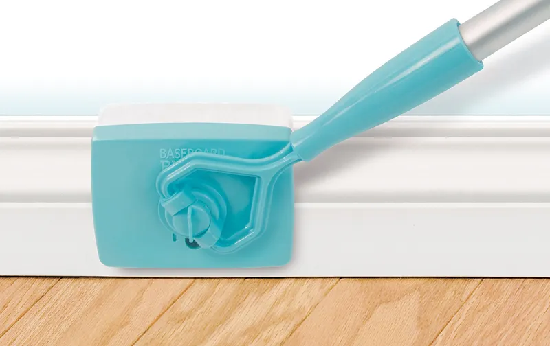 Cleaning head and pad wrapped over the top edge of a baseboard